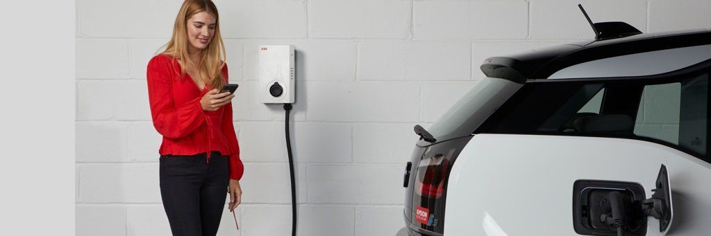 Wallbox an einer Hauswand lädt ein Elektroauto